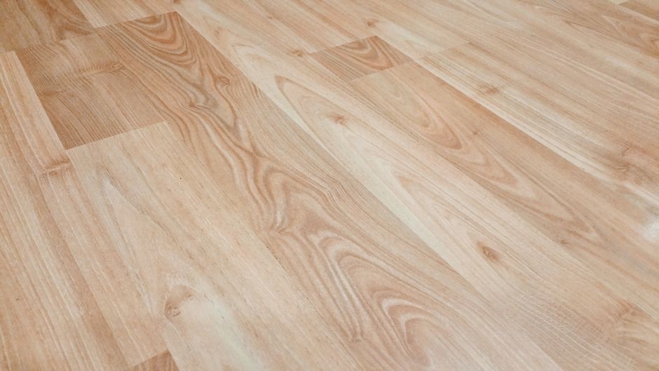 A freshly finished hardwood floor with a sheen indicating a recently applied coat